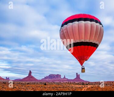 Ein Heißluftballon fliegen vor dem Utah Denkmäler im Monument Valley Ballon Festival im Monument Valley Navajo Tribal Park in Arizona. Stockfoto