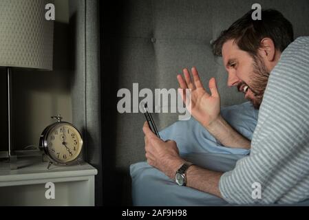 Mann morgen Nachrichten auf sein Smartphone Gerät reagieren. Stockfoto