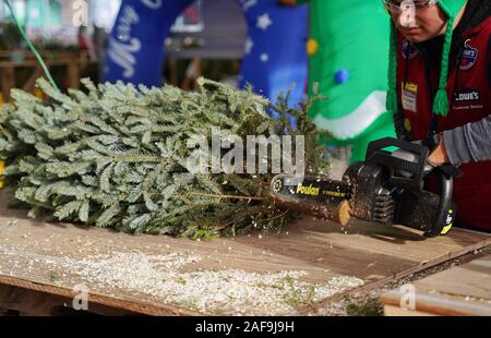 Cromwell, CT USA. Dez 2019. Elektrische Kettensäge in Aktion während der Weihnachtsferien als Home Improvement Store Mitarbeiter Verkleidungen Baum warten auf Benutzerdefinierte Stockfoto