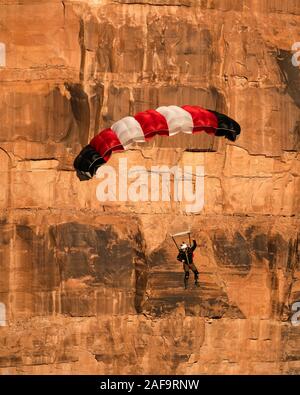 Ein Base Jumper fällt in seinem Fallschirm aus der 400-Fuß vertikale Teilfläche der Tombstone in der Kane Springs Canyon in der Nähe von Moab, Utah. Stockfoto