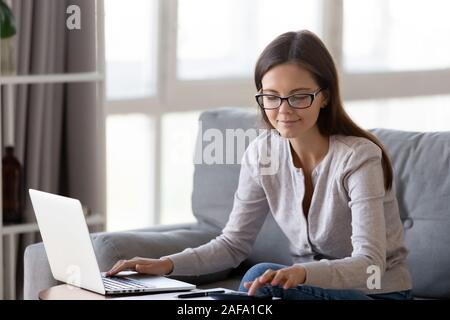 Lächelnden jungen Frau Aufwendungen zu Hause berechnen Stockfoto