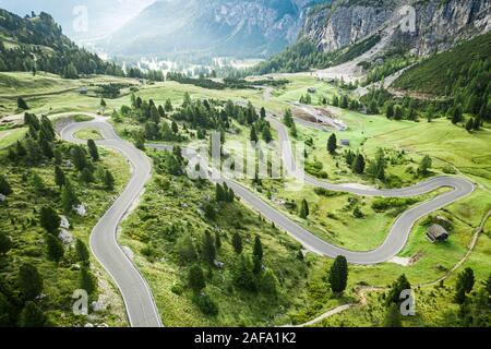 Kurvenreiche Straße und grüne Hügel, Grödner Joch, Dolomiten, Luftaufnahme Stockfoto