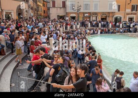 Riesige Menschenmengen am Trevi-Brunnen in Rom selfies und Münzen in den Brunnen für Glück werfen. Sicherheit jetzt verhindern, dass Menschen aus dem Sitzen Stockfoto