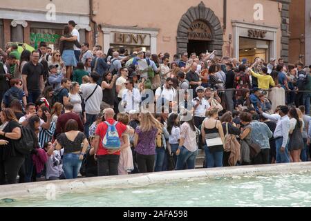 Riesige Menschenmengen am Trevi-Brunnen in Rom selfies und Münzen in den Brunnen für Glück werfen. Sicherheit jetzt verhindern, dass Menschen aus dem Sitzen Stockfoto