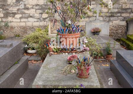 Das Grab der französische Romancier und Dramatiker Marguerite Duras in Friedhof Montparnasse ist mit Stiften und Token durch Besucher und Fans links abgedeckt Stockfoto