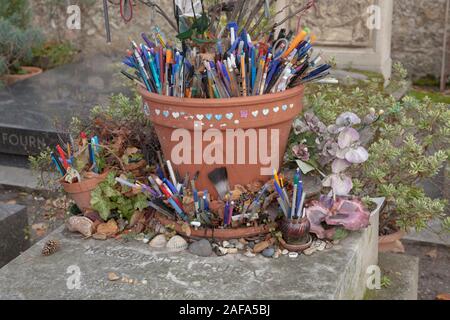 Das Grab der französische Romancier und Dramatiker Marguerite Duras in Friedhof Montparnasse ist mit Stiften und Token durch Besucher und Fans links abgedeckt Stockfoto