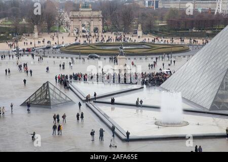 Eine Warteschlange am Eingang Glaspyramide im Innenhof des Louvre in Paris mit Blick auf den Arc de Triomphe du Carrousel Stockfoto