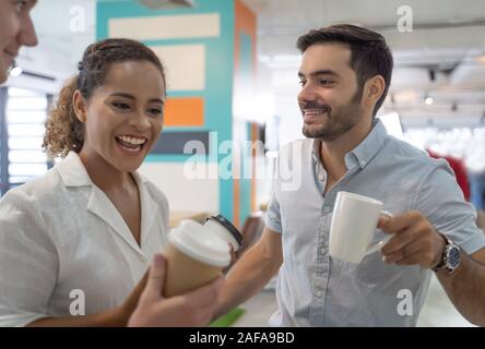 Unternehmen, die Menschen sprechen und halten Tassen Kaffee. Gruppe von Mitarbeitern mit einer Kaffeepause im Büro. Stockfoto