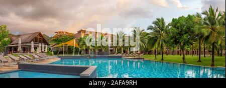 Khao Lak, Thailand, 30. November 2019: Panorama der schicke 5-Sterne Hotel mit Pool der Sandstrand von Kata. Abend um, Palmen und grünen Gras Stockfoto