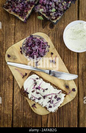 Scheibe Vollkornbrot mit frisch geschnittenen Kresse und Frischkäse auf einem alten Holztisch (selektive Fokus, Nahaufnahme) Stockfoto