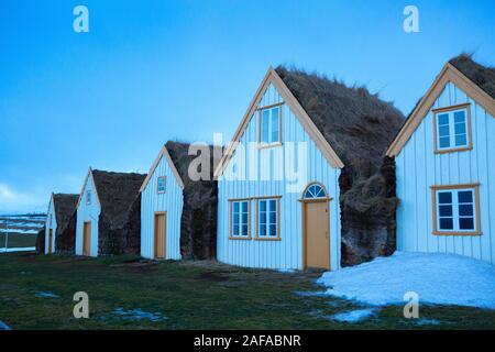 Typisch isländischen Torfhäuser bei Dämmerung im Winter, North Island. Stockfoto