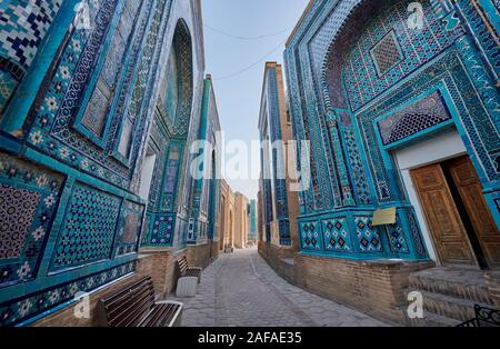 Schmale Pfad durch Fassaden stark dekoriert mit blauen Kacheln in der nekropole Schah-i-Wonders, Samarkand, Usbekistan, in Zentralasien Stockfoto