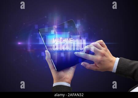 Geschäftsmann Holding ein aufklappbares Smartphone mit Maschine Inschrift, neue Technologie Konzept Stockfoto