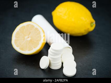 Einige Vitamin-C-Tabletten auf einer Schiefertafel Platte als detaillierte Nahaufnahme; selektive Fokus Stockfoto