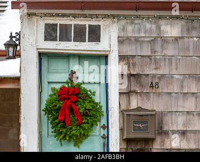 Alte verblasst grüne Tür mit Weihnachten Kranz Stockfoto