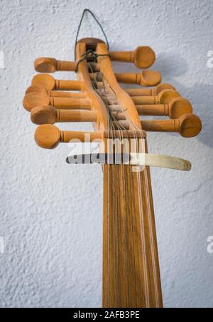 Spindelstock mit Abholung, Plektrum aus Horn, auf Strings einer alten arabischen Oud Instrument. Stockfoto