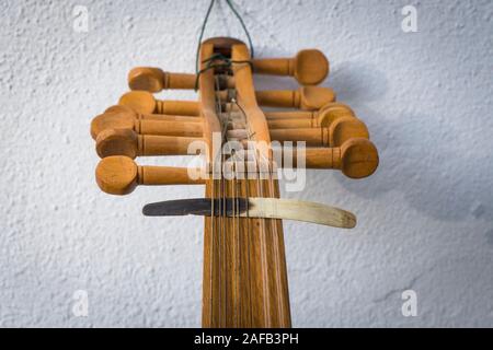 Spindelstock mit Abholung, Plektrum aus Horn, auf Strings einer alten arabischen Oud Instrument. Stockfoto