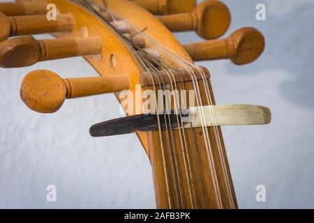 Spindelstock mit Abholung, Plektrum aus Horn, auf Zeichenketten eines alten Oud arabische Musik Instrument. Stockfoto