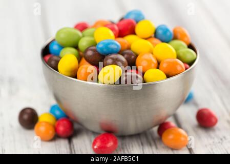 Frischen Cocolate beschichtet Erdnüsse auf einem vintage Hintergrund (Nahaufnahme) Stockfoto