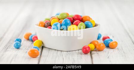 Cocolate beschichtet Erdnüsse auf rustikalen Holzmöbeln Hintergrund (Nahaufnahme) Stockfoto