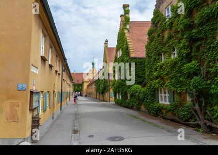 Blick auf die Hauptstraße in Richtung Haupteingang in der Fuggerei, einen Ummauerten Enklave innerhalb der Stadt Augsburg, Bayern, Deutschland. Stockfoto