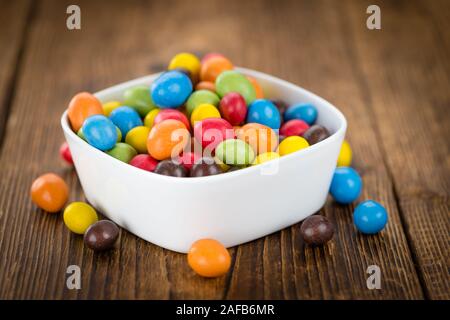 Cocolate beschichtet Erdnüsse auf rustikalen Holzmöbeln Hintergrund (Nahaufnahme) Stockfoto