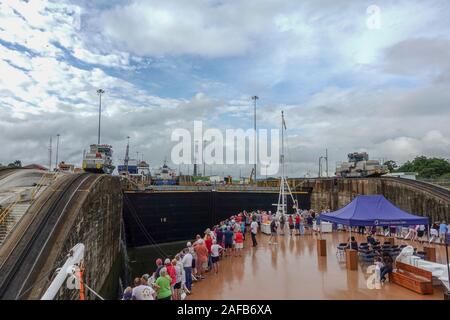 Panama - 11/6/19: ein Kreuzfahrtschiff mit den Passagieren auf dem Bug des Schiffes beobachten Sie die erste Schleuse des Panamakanals. Stockfoto