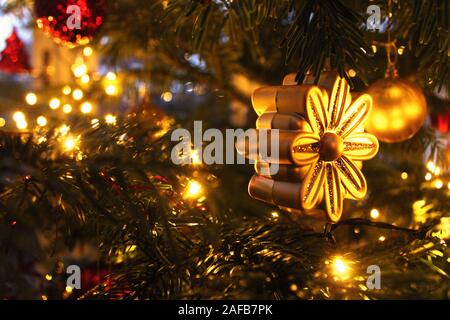 Gold Blume Weihnachtsverzierung auf einem geschmückten Weihnachtsbaum Stockfoto