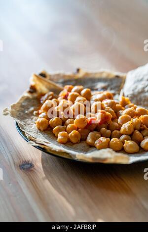 Tortilla Kichererbse Wrap Samosa Buritto mit Fladenbrot bereit zu Essen, mit Tageslicht, Holztisch. Traditionelle Speisen. Stockfoto