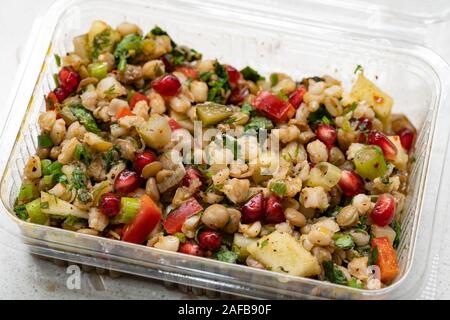 Instant Nehmen gesunde Salate mit Weizen, Linsen, Granatapfel Samen, Essiggurken und Birne Schichten in Kunststoffbox/Package Container. Ökologische Lebensmittel. Stockfoto