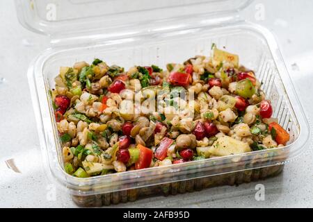 Instant Nehmen gesunde Salate mit Weizen, Linsen, Granatapfel Samen, Essiggurken und Birne Schichten in Kunststoffbox/Package Container. Ökologische Lebensmittel. Stockfoto