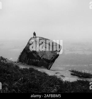 Eine Person steht auf der Wade (der Kuh und Kalb Felsen auf Ilkley Moor) und bewundert die Aussicht, Ilkley, West Yorkshire, UK Stockfoto