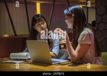 Asiatische Geschäftsfrau im Laufe der Zeit arbeiten, über die Arbeit diskutieren Stockfoto