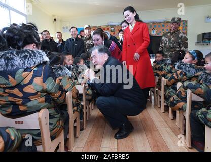 (191214) - Peking, Dez. 14, 2019 (Xinhua) - Wang Yang, Mitglied des Ständigen Ausschusses des Politbüros der Kommunistischen Partei Chinas und Vorsitzender des Nationalen Ausschusses der Chinese People's Political Consultative Conference, Gespräche mit einem Kind in Aimin Kindergarten in Autonomen Präfektur Liangshan Yi, der Südwesten Chinas Provinz Sichuan, Dez. 12, 2019. China's Top politischer Berater Wang Yang betont hat, Anstrengungen, um sicherzustellen, dass keine ethnische Gruppe, die im Zuge des Aufbaus einer mäßig wohlhabenden Gesellschaft in jeder Hinsicht verlassen wird. Er war auf einer Inspektion Stockfoto