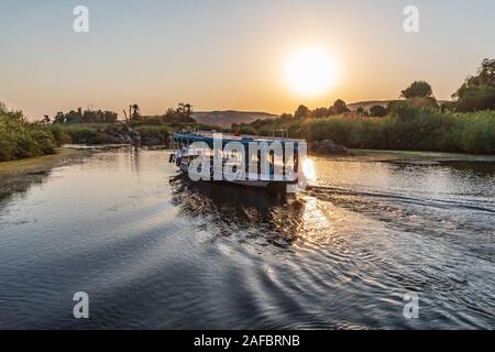 Afrika, Ägypten, Assuan. Oktober 8, 2018. Touristische Bootsfahrt auf dem Nil bei Sonnenuntergang in der Nähe von Assuan. Stockfoto