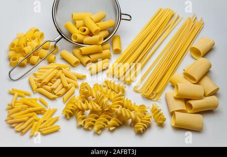 Sieb und verschiedene Arten von Pasta, gesehen von oben Stockfoto