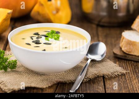 Selbstgemachte Kürbissuppe (selektive Fokus) auf rustikalen Hintergrund als Nahaufnahme Stockfoto