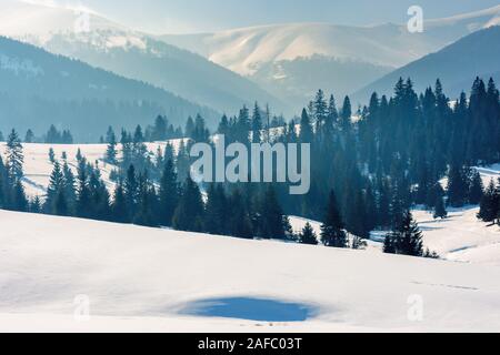 Bergige Landschaft im Winter. Wunderschöne Landschaft auf einem hellen, sonnigen Tag. Wald auf Schnee rollenden Hügeln Fichte. wunderschöne Landschaft des borzhav Stockfoto