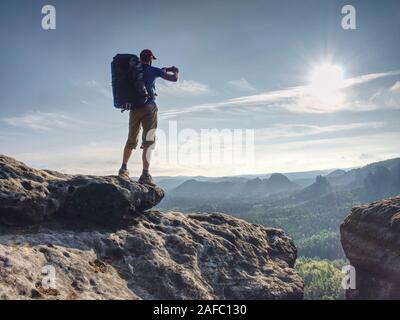 Wanderer Hände und Telefon, wunderschönen Sonnenuntergang morgen, Wandern inmitten alter Mann suchen nach etwas Stockfoto