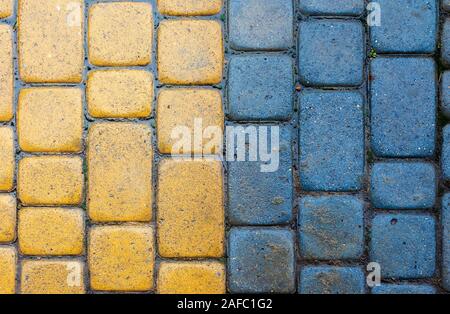 Gelb und Blau Kopfsteinpflaster Bürgersteig Textur. steinmetzkunst Bodenbelag. nach oben Blick auf vertikale Nass grungy Hintergrund Stockfoto