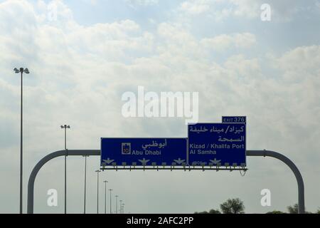 Auf dem modernen Autobahn zwischen Dubai und Abu Dhabi, ein Schild ist in arabischer und englischer Sprache geleitet. Stockfoto