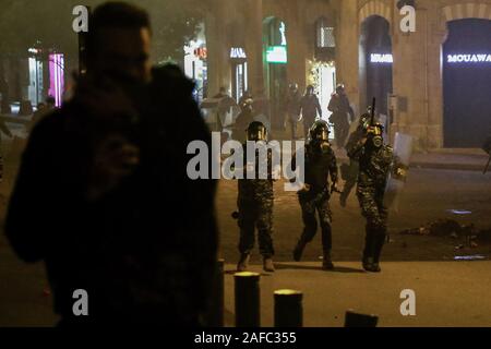 Beirut, Libanon. 14 Dez, 2019. Libanesische Polizisten laufen während der Auseinandersetzungen mit Demonstranten in der Nähe des libanesischen Parlaments Gebäude. Credit: Marwan Naamani/dpa/Alamy leben Nachrichten Stockfoto