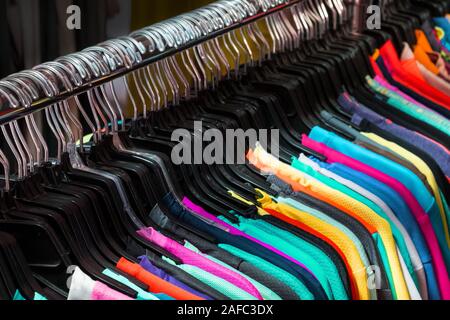 T-Shirts auf Kleiderbügeln in Second Hand Kleidung Store Stockfoto