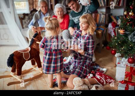 Cute kid ein Weihnachtsgeschenk von ihrer Familie Stockfoto