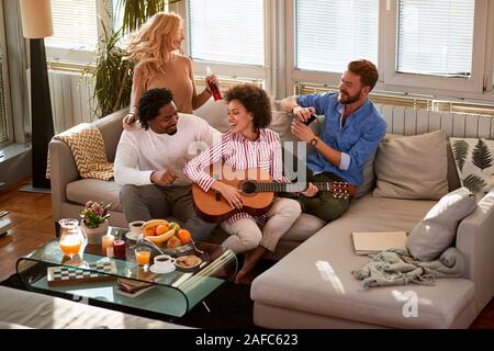 Gruppe Freunde Spaß mit Gitarre und trinken zu Hause Stockfoto