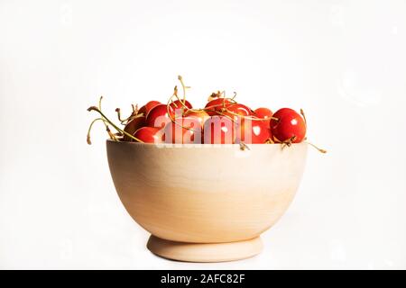 Frische süße reife Kirschen in einer Holzschale isoliert auf weißem Grund. Seitenansicht. Stockfoto