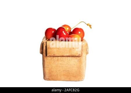 Frische süße reife Kirschen in einer Keramikkiste, isoliert auf weißem Grund. Seitenansicht. Stockfoto