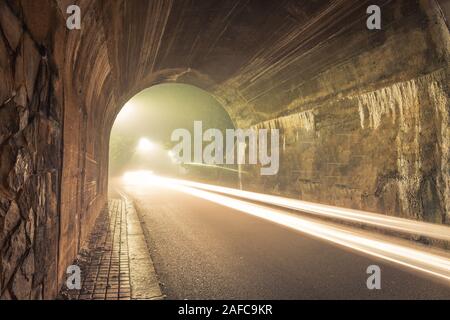 Der Tunnel. Weise, mit gespenstischen Dunst und Nebel in der Nacht mit loght Trails von Auto. Stockfoto