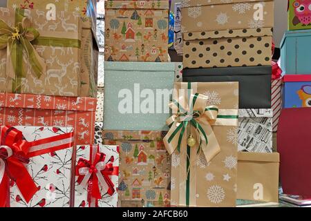 Mehrfarbige Geschenkboxen mit Bögen. Papier Boxen für die Dekoration Geschenke für die Feiertage. Viele Geschenkboxen stand auf der jeweils anderen. Stockfoto