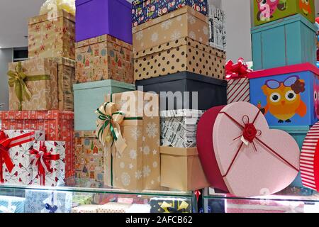 Mehrfarbige Geschenkboxen mit Bogen in der Mall. Papier Boxen für die Dekoration Weihnachtsgeschenke. Viele Geschenkboxen stand auf der jeweils anderen. Stockfoto